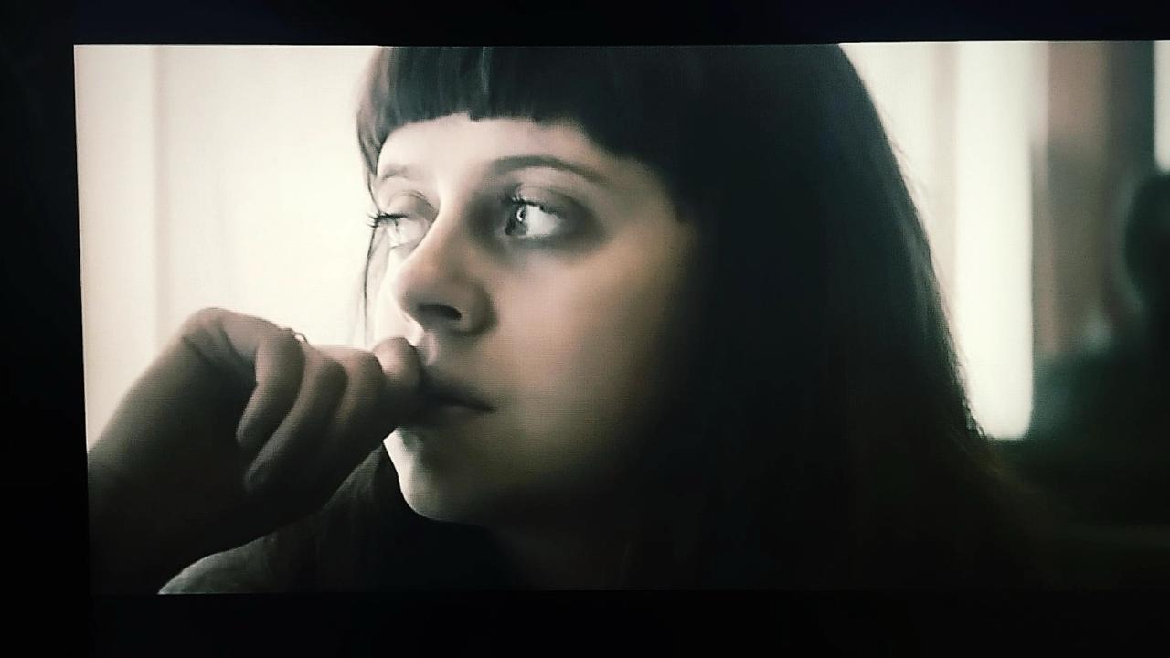 Film still — a portrait held in soft window light